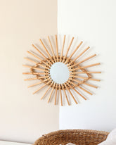 a sun shaped mirror hanging on a wall